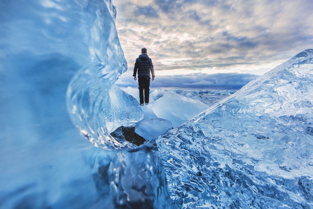 Explorer walking across glacial ice at sunset, representing the pathway toward polar expedition readiness.