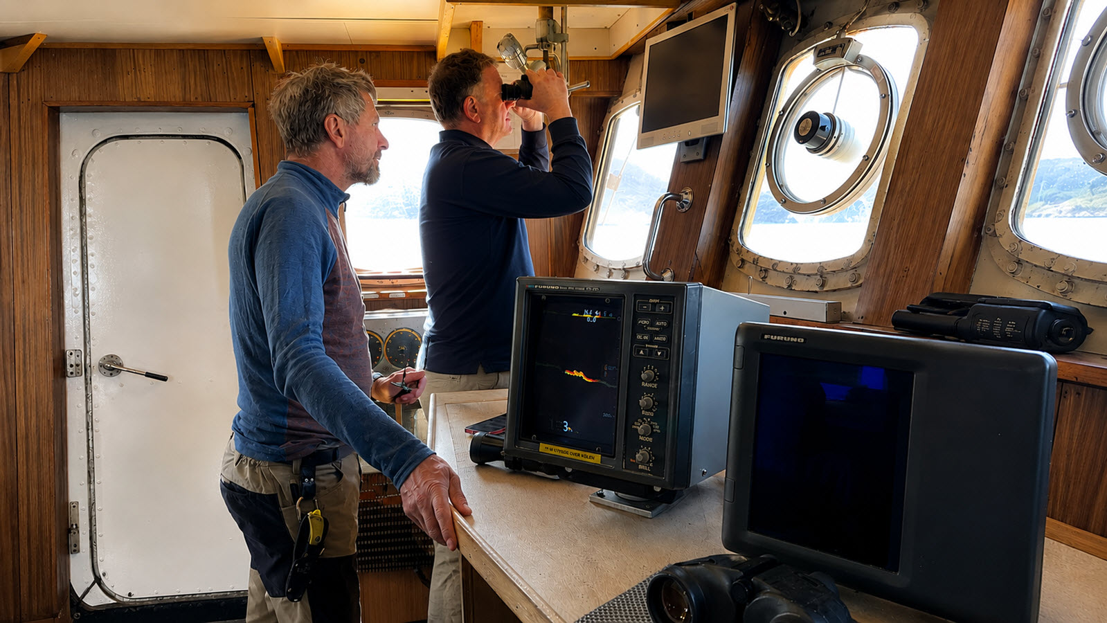 Expedition leads reviewing sonar and charting a route from the wheelhouse